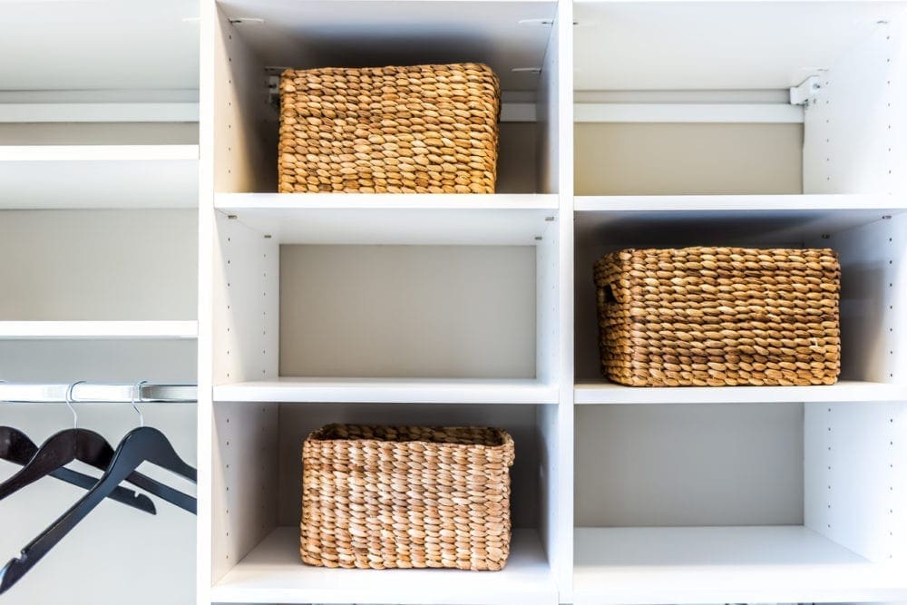 plain white shelves with woven baskets, making an organized closet