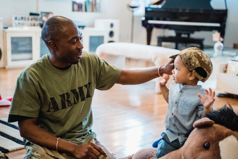 army dad putting cap on son